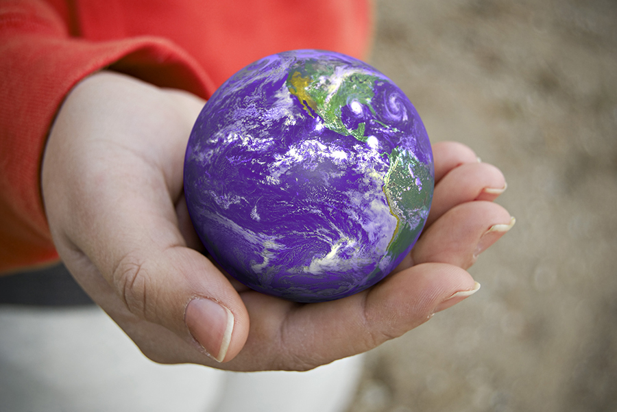 a person holding a ball that looks like the planet earth
